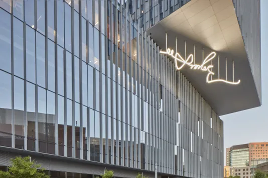 Glass mirrored buildings with a white LED sculpture on the buildings underhang.