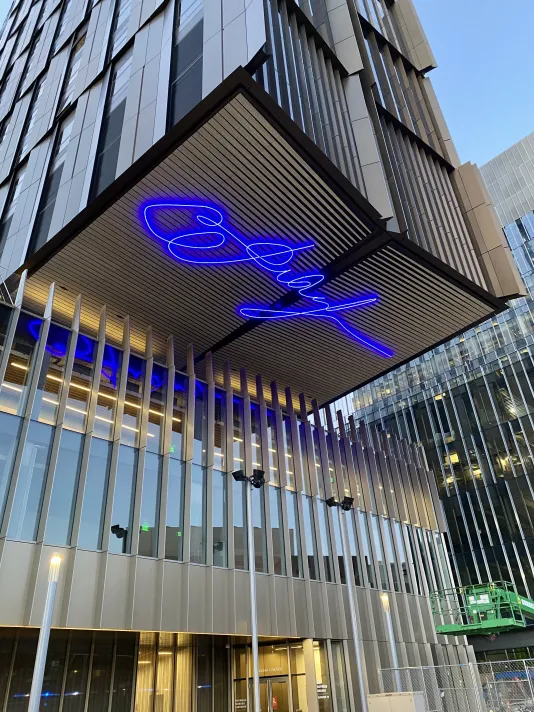 Large-scale animated LED sculptures that spell out a signature on the underside of a building overhang